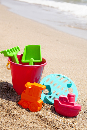 plastic toys on the beach ready for playing with sandの写真素材