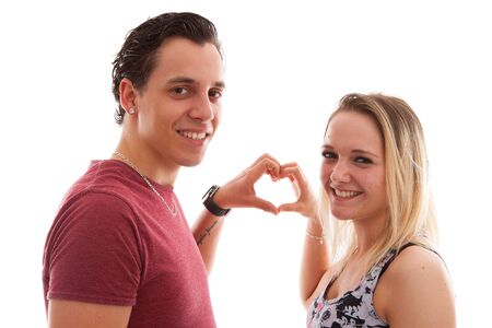 Young couple in lovemaking heart with hands over white backgroundの写真素材