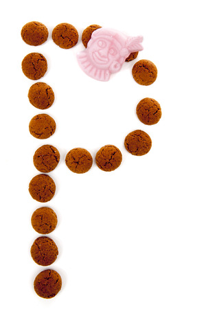Ginger nuts, pepernoten, in the shape of letter P isolated on white background. Typical Dutch candy for Sinterklaas event in decemberの写真素材