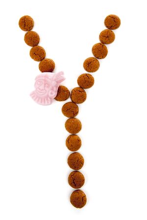 Ginger nuts, pepernoten, in the shape of letter Y isolated on white background. Typical Dutch candy for Sinterklaas event in decemberの写真素材