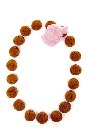 Ginger nuts, pepernoten, in the shape of letter O isolated on white background. Typical Dutch candy for Sinterklaas event in decemberの写真素材