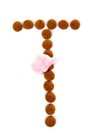 Ginger nuts, pepernoten, in the shape of letter T isolated on white background. Typical Dutch candy for Sinterklaas event in decemberの写真素材