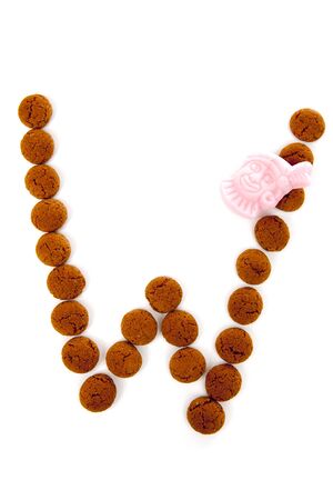 Ginger nuts, pepernoten, in the shape of letter W isolated on white background. Typical Dutch candy for Sinterklaas event in decemberの写真素材