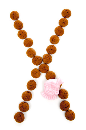 Ginger nuts, pepernoten, in the shape of letter X isolated on white background. Typical Dutch candy for Sinterklaas event in decemberの写真素材