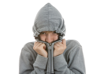 Boy is hiding in his hoodie over white backgroundの写真素材
