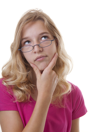 Teenange girl is thinking with hand unde chin isolated on white backgroundの写真素材