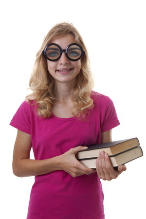 Teenage female student is looking in camera with weird glasses on holding books over white backgroundの写真素材