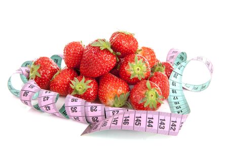 Diet scenery with measuring tape and fresh strawberries over white backgroundの写真素材