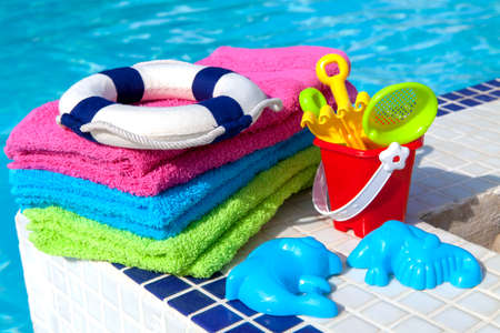 Towels and children toys near the swimming poolの写真素材