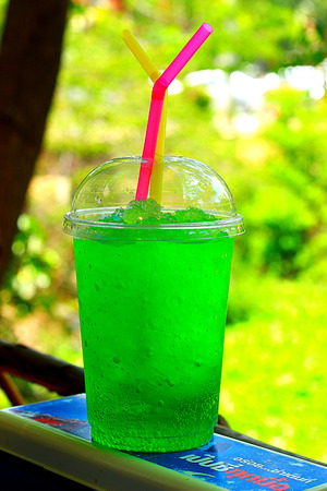 Green water in glass with straw.の写真素材