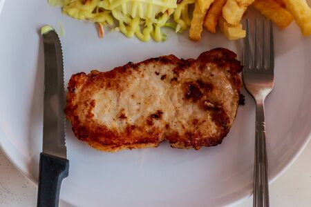 Close up of pork steak on a white plateの写真素材