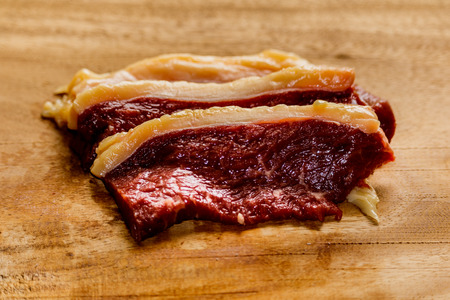 Raw fresh pork meat on cutting board on wooden tableの写真素材