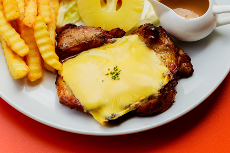 Grilled pork steak French fries and sauce on White plateの写真素材