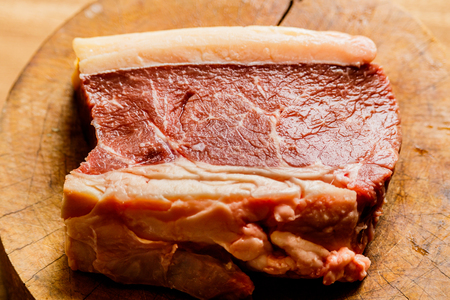 Raw fresh pork meat on cutting board on wooden tableの写真素材