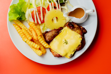 Grilled pork steak French fries and sauce on White plateの写真素材