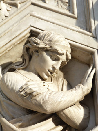 Irreverent angel on the facade of the cathedral of Florence, Italyの写真素材