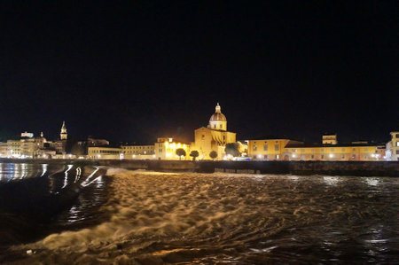 The Arno river in flood at night at the weir of Santa Rosa in Florence, Italyの写真素材