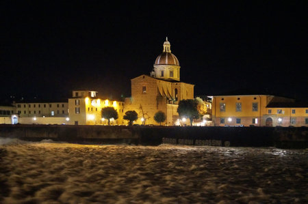 The Arno river in flood at night at the weir of Santa Rosa in Florence, Italyの写真素材