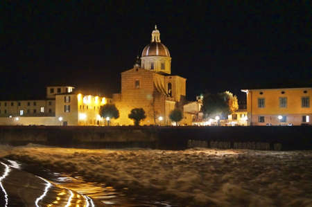 The Arno river in flood at night at the weir of Santa Rosa in Florence, Italyの写真素材