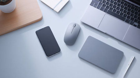 This image showcases a modern minimalist workspace featuring a laptop, smartphone, mouse, and sleek accessories, ideal for office or study use.の素材