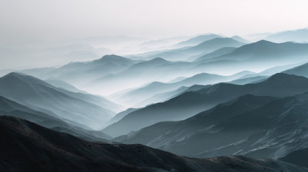 This stunning photo captures serene layers of mountains shrouded in fog and mist, creating a tranquil atmosphere under soft dusk light.の素材