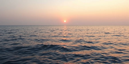 Experience the beauty of a tranquil sunset over the ocean, where gentle waves reflect a stunning array of warm colors in the sky.の素材