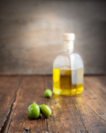 olive oil with several olives on rustic background isolatedの写真素材