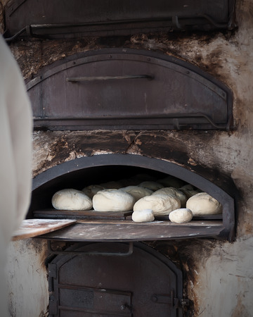 Introducing mass baker of bread in wood stoveの写真素材