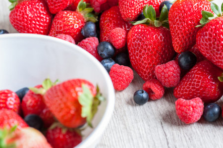 still life of strawberries with berries and raspberries isolated in the foreground
