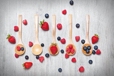 various fruits placed with wooden spoons with rustic backgroundの写真素材