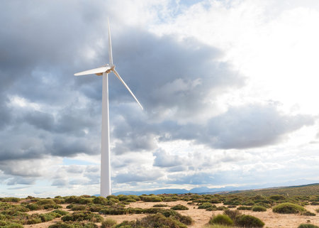 various mountain wind turbine with green grass and cloudy sky