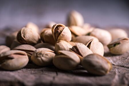 pistachios on wooden table in the foreground with darkened background
の写真素材