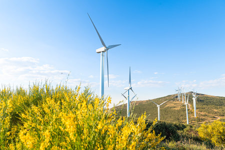 turnina wind in the foreground with green countryside and bluish sky