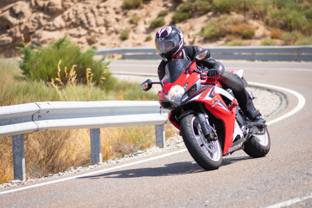 Motorcyclist taking a curve in the port of Navalmoral, province of Avila, Spain, during the month of September 2020のeditorial素材