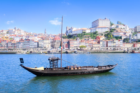 Luiz I bridge of the city of Porto, in foreground with colorful background and various boats on the estuary sailingの写真素材