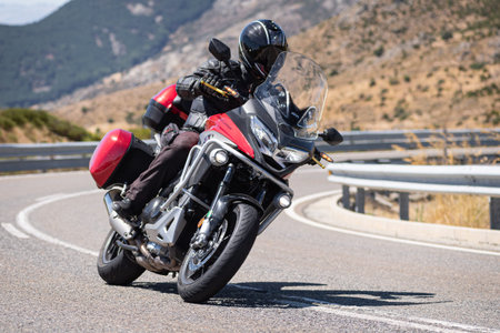 Man on his motorcycle taking a curve on a sunny day. Photograph taken in the town of Navalmoral de...