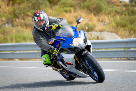 Man on motorcycle carving a tight bend in Puerto de Navalmoral, Ãvila, August 2023