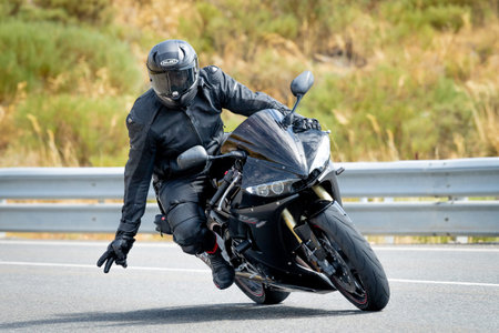 Man on motorcycle carving a tight bend in Puerto de Navalmoral, Ãvila, August 2023