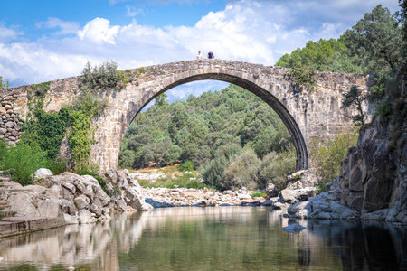 Majestic ancient Roman stone bridge, towering height dominates the valley with historic arches.の写真素材