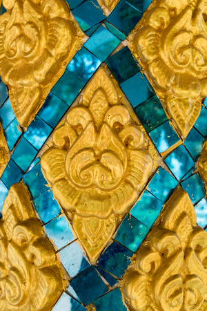 Thai ancient gold plaster stucco and color glass in templeの写真素材