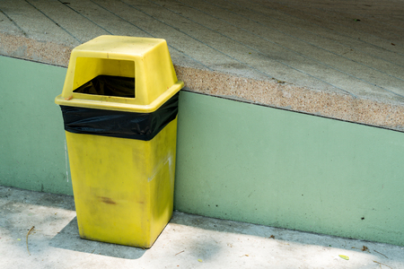 Yellow Trash can on concrete wall backgroundの写真素材