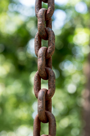 Rusty chain on green blurred backgroundの写真素材