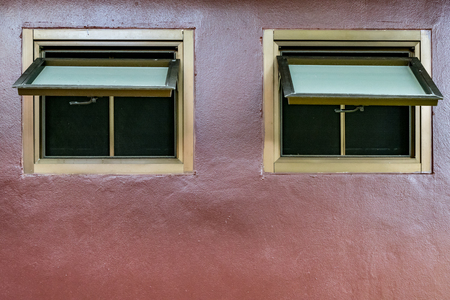 Awning windows on brown concrete wallの写真素材