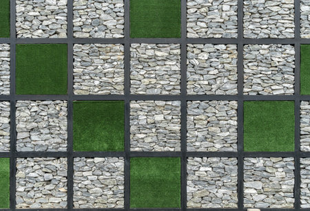 Stone wall block with green artificial grass background