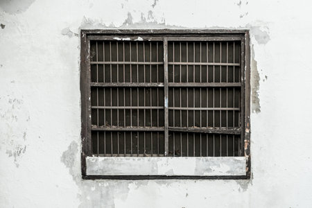 Old jail's window on white wallの写真素材