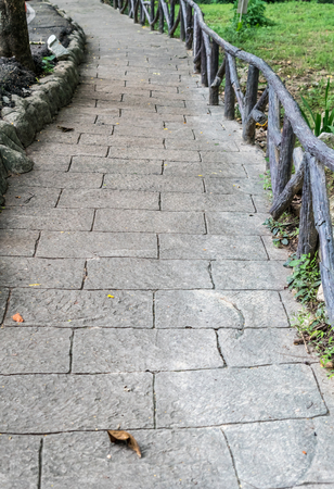 Concrete pathway with artificial tree branch railing in the parkの写真素材