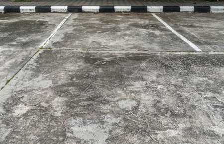 Empty car park with black and white concrete curbの写真素材