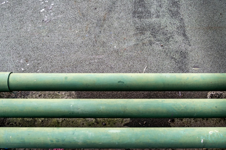 Green water pipe on concrete floorの写真素材
