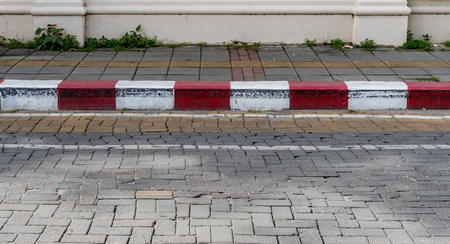 Concrete sidewalk with red and white curbの写真素材