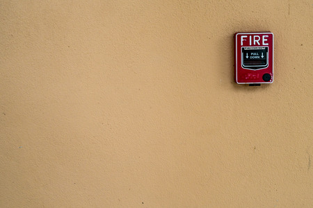 Red fire switch on concrete wallの写真素材